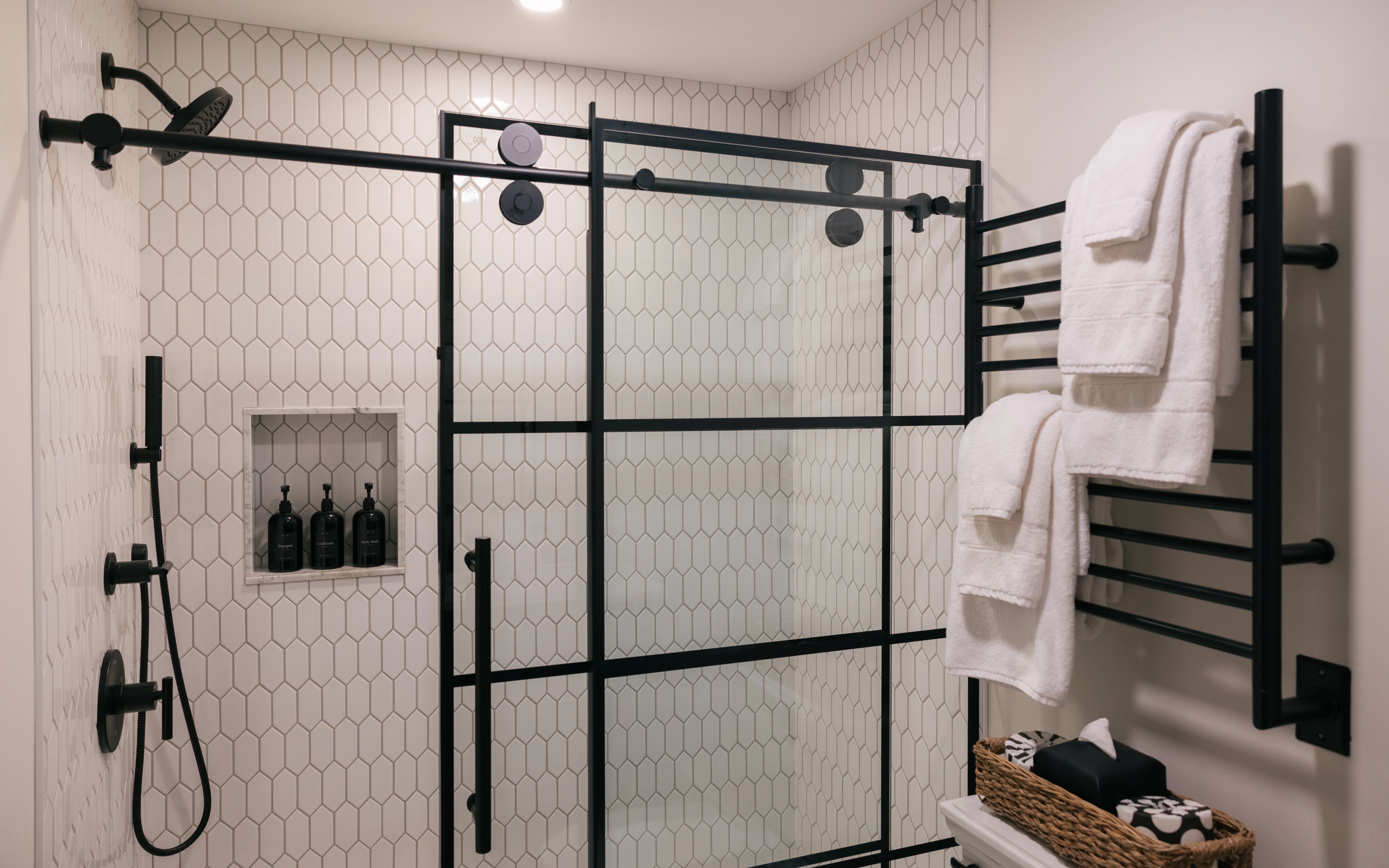 Downstairs king ensuite bath with stylish tile, matte black fixtures, and clean modern finishes